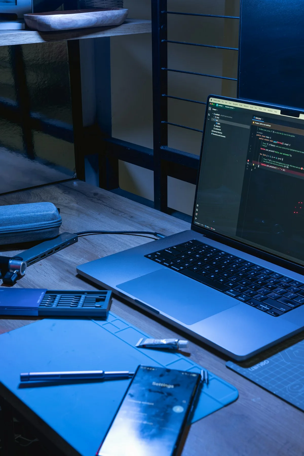 Laptop displaying source code beside a phone